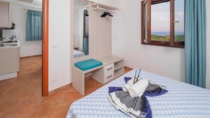 A bedroom with a bed, a desk, a mirror, and a view of the outdoors. - Beautiful home in Marina di Modica (Marina di Modica)