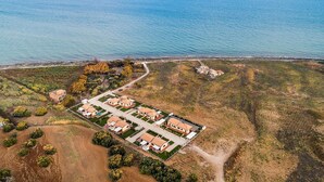 An aerial view of a coastal residential area with a cluster of houses and a paved road leading to the beach. - Beautiful home in Marina di Modica (Marina di Modica)