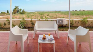 A terrace with white chairs and a table, a book, and a glass of orange juice. - Beautiful home in Marina di Modica (Marina di Modica)