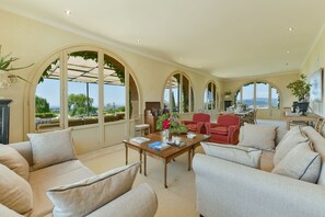 A spacious living area with a large window, a dining table, and comfortable seating.