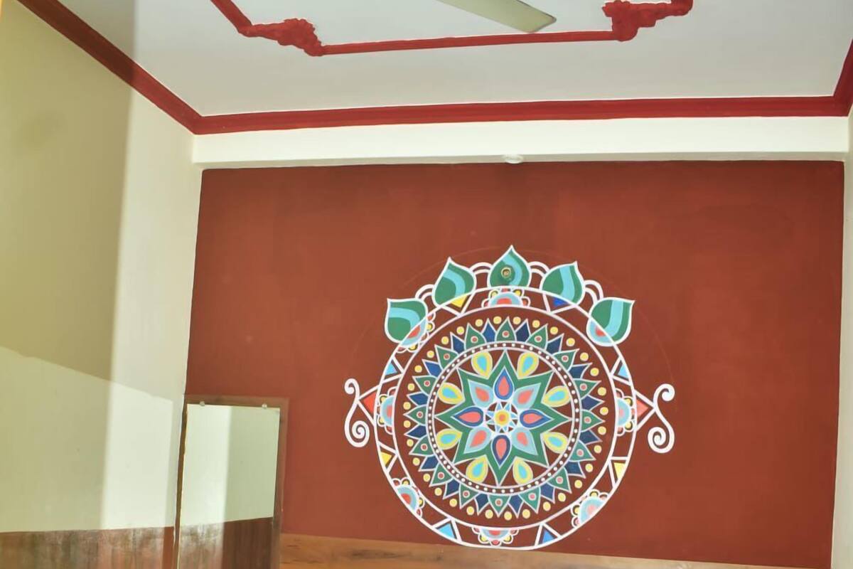 A hotel room with a bed, a ceiling fan, and a decorative wall hanging.