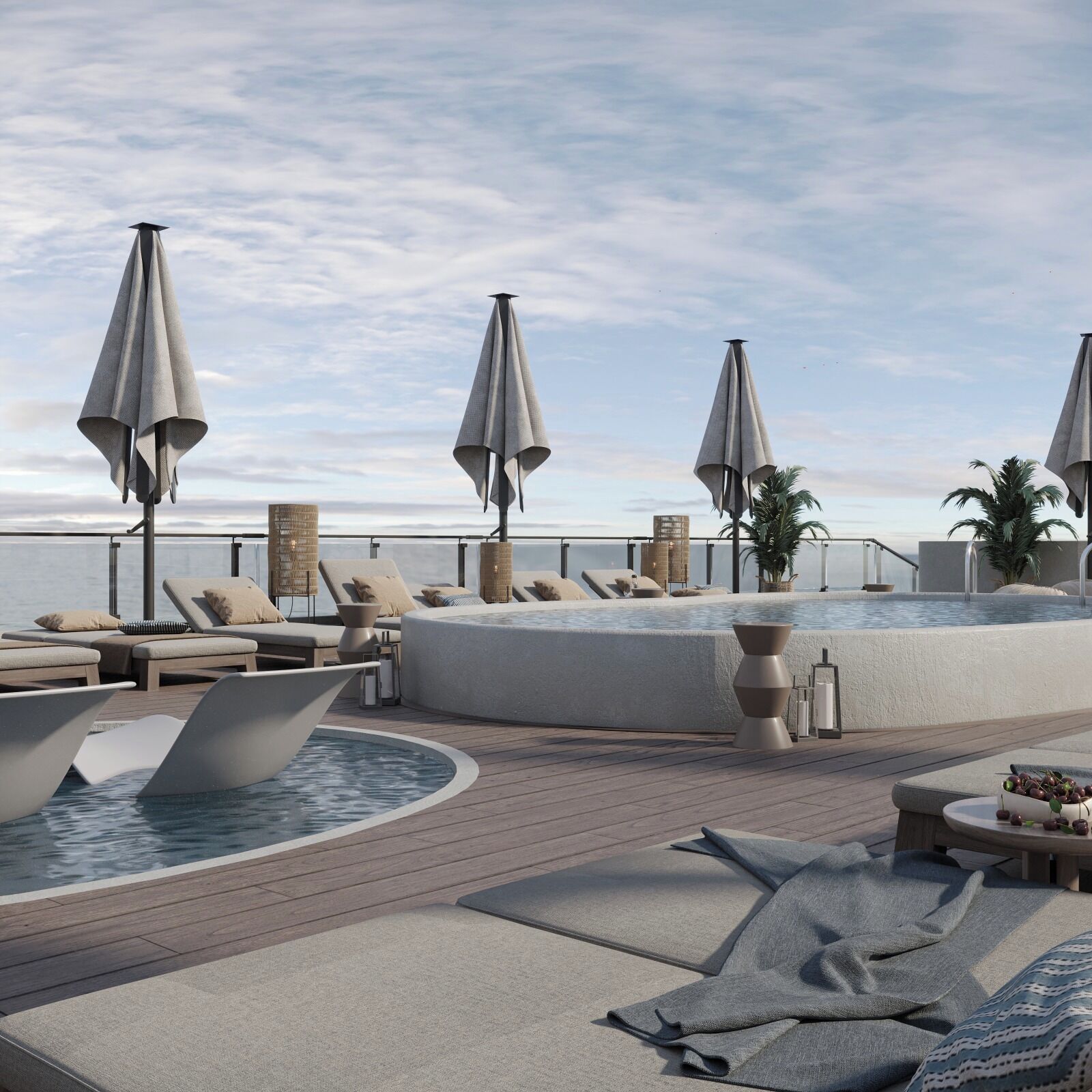 A rooftop pool area with lounge chairs, umbrellas, and a hot tub.