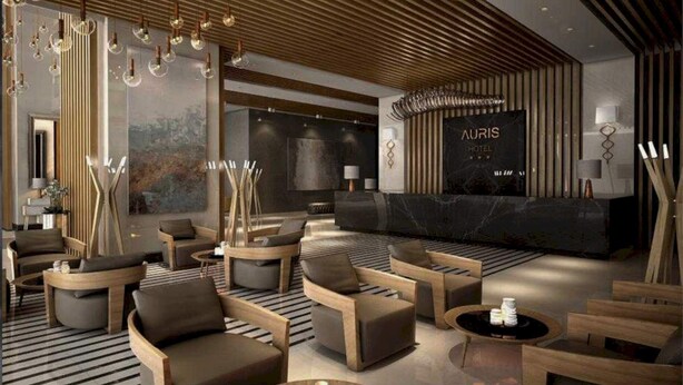 Een moderne hotellobby met een receptiebalie, een zithoek en kunstwerken aan de muren.
