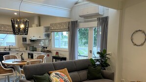 En moderne stue med en hjørnesofa, et spiseområde og et køkken.