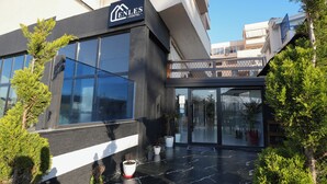 A modern building with a sign reading "ENLES HOSTEL" and a glass entrance. - Enles Hotel (Durrës)