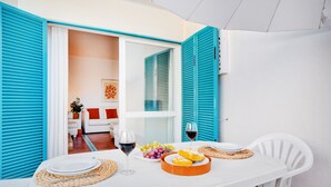 A dining table set with plates, cutlery, a glass of red wine, and a fruit platter. - Prainha Calm Retreat in Alvor (Portimão)