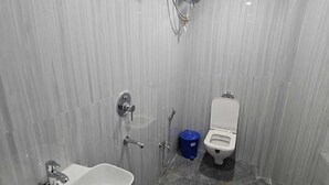 A bathroom with a sink, toilet, shower, and a water heater. - The Shivaay Palace (Varanasi)