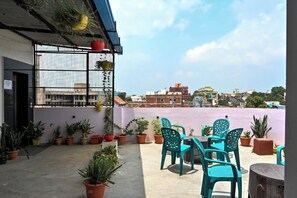 A rooftop terrace with potted plants, a table, and chairs. - The Shivaay Palace (Varanasi)