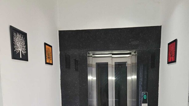 Een lift met een metalen inrichting en een digitaal scherm aan de wand.