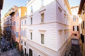 A narrow street with multi-story buildings, some with balconies and shutters. - Historical Apartment near Piazza Navona (Rome)