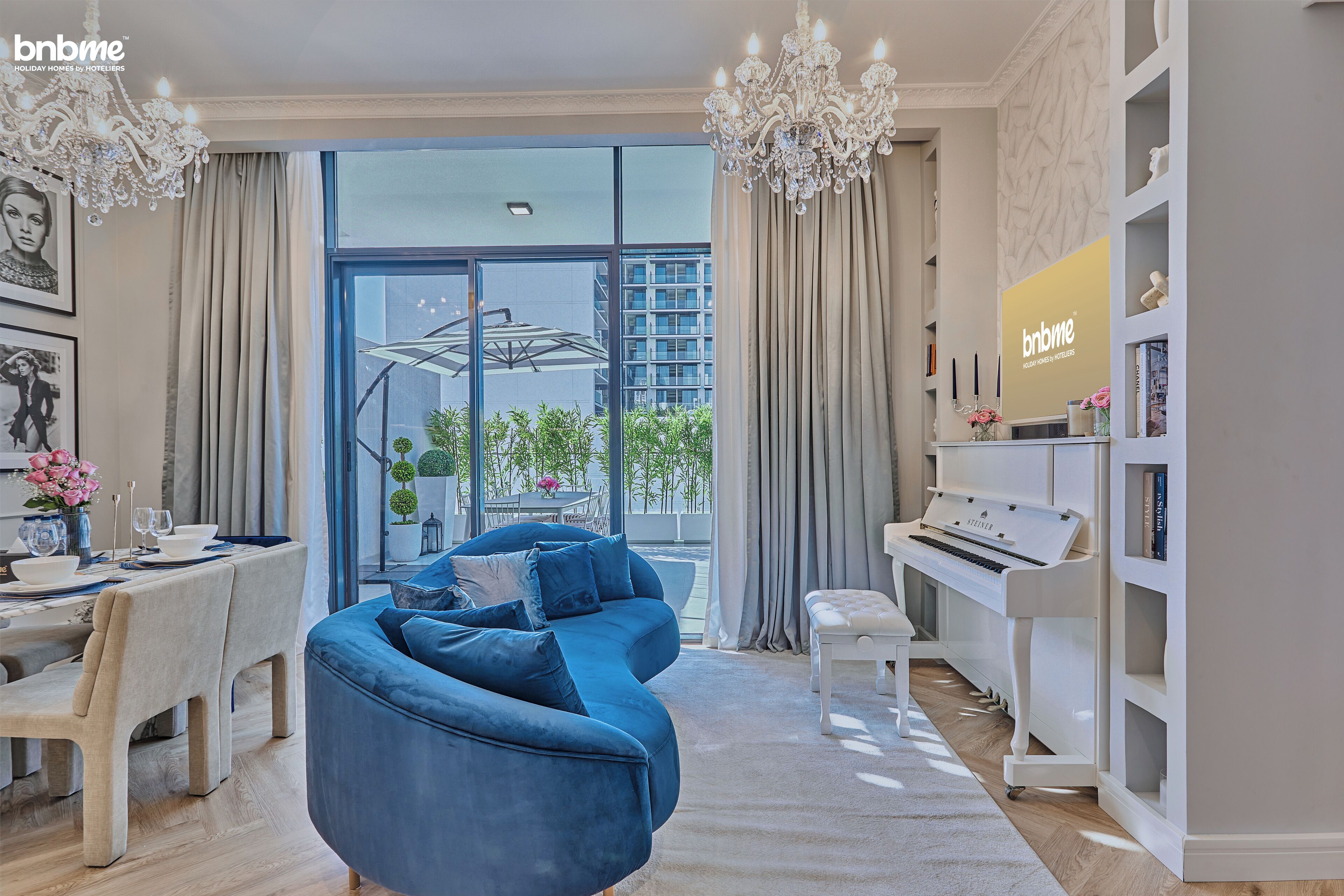 Un salon moderne avec un canapé bleu, un piano et un coin repas comprenant une table et des chaises.