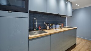 A modern kitchen with grey cabinets, a wooden countertop, and a built-in oven. - Superb AC Apartment Center of Paris (Paris)