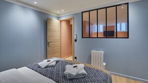 A bedroom with a bed, a wardrobe, a radiator, and a sliding door. - Superb AC Apartment Center of Paris (Paris)