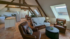 A cozy loft-style living space with exposed wooden beams, a kitchen area, and a dining nook. - Cottage in forest with garden, terrace and parking near Loire (Saint-Firmin-sur-Loire)