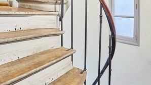 A staircase with wooden steps and a curved metal railing. - Charming Duplex - Louvre Museum (Paris)