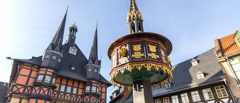 A historic building with a prominent tower and a decorative fountain.