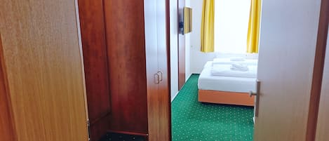 Una habitación de hotel con una cama, un armario y una pequeña escalera.