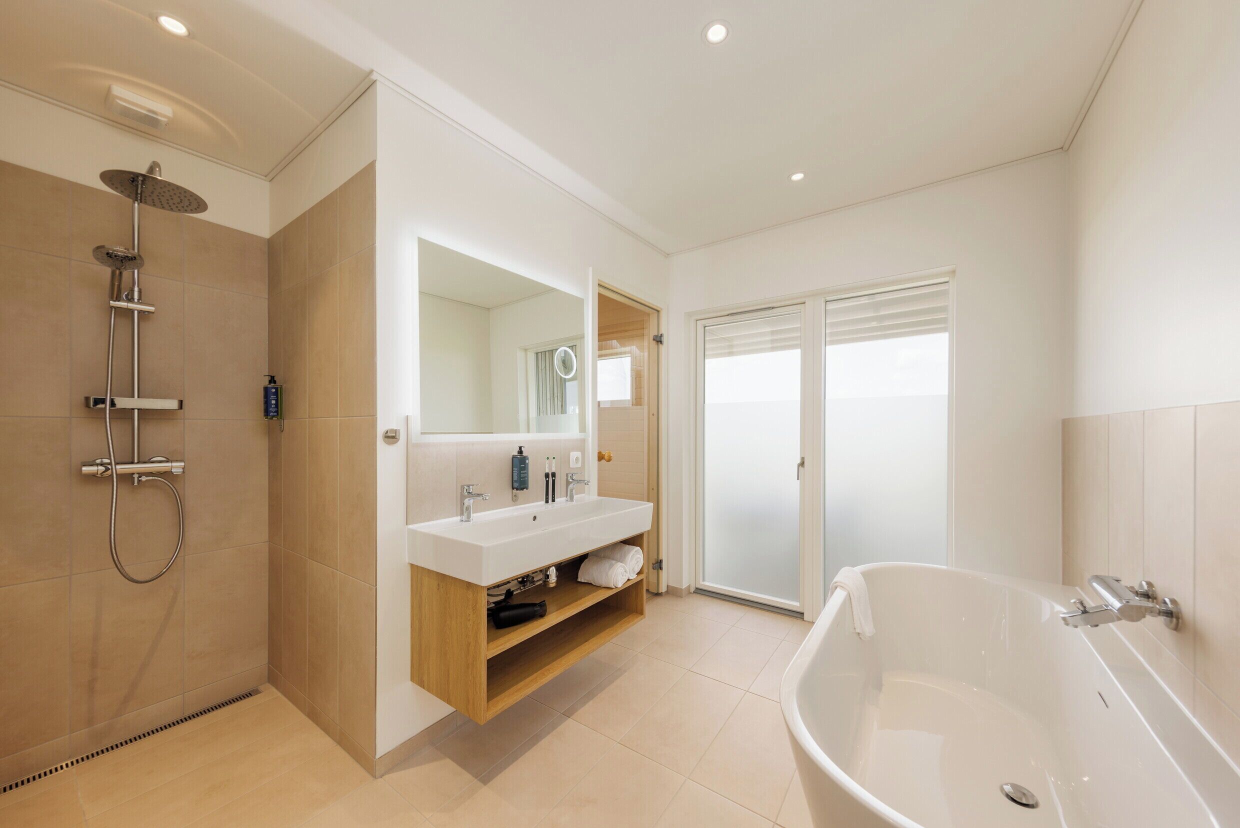 A modern bathroom with a shower, sink, and bathtub.