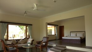 A spacious living area with a sofa, two armchairs, a coffee table, and a large bed in the background. - YAAN Bagela Villa (Udaipur)