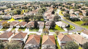 A residential area with houses, roads, and a swimming pool.