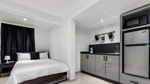Een moderne slaapkamer met een bed, nachtkastje en een inbouwkast.