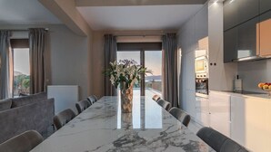 A modern kitchen with a marble countertop, a built-in oven, and a fruit bowl on the counter.