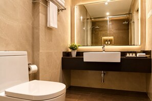 A modern bathroom with a toilet, sink, and shower. - Hotel Chariot Inn Patna (Patna)