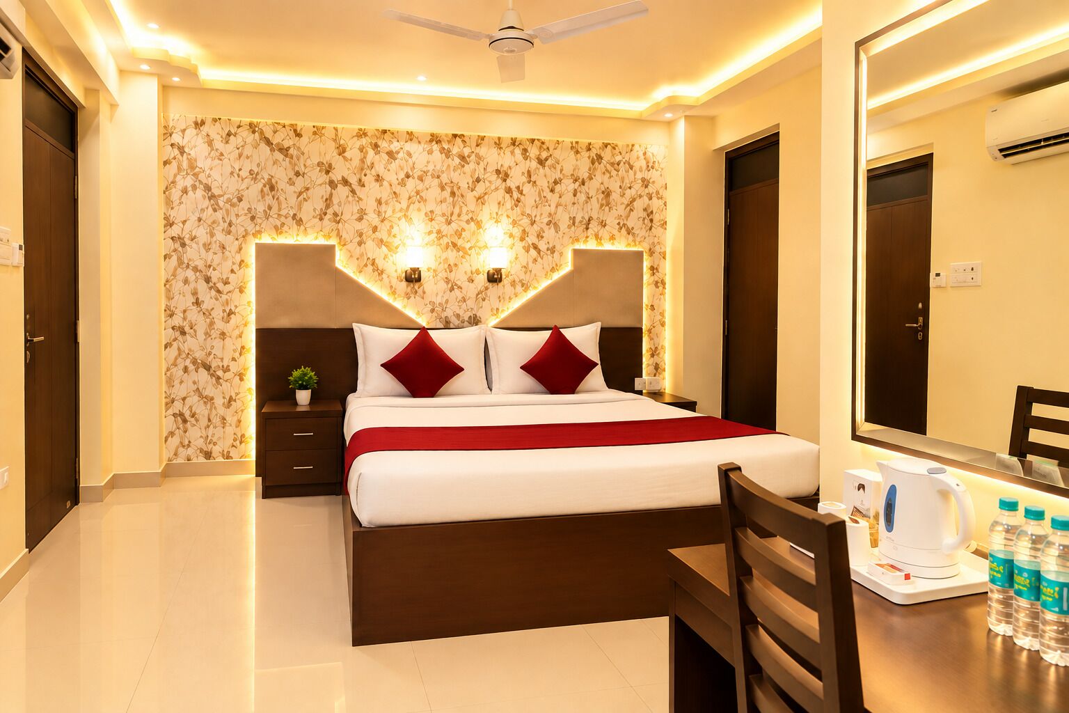 A hotel room with a bed, bedside tables, a desk with a chair, a mirror, and a ceiling fan.