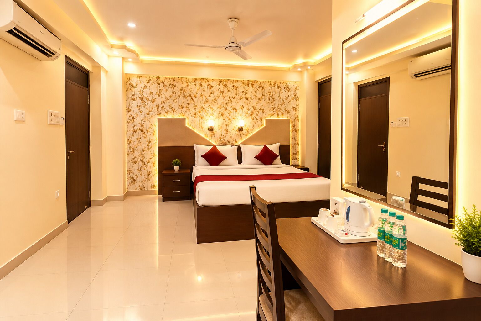 A hotel room with a bed, bedside table, mirror, and a desk with a chair.