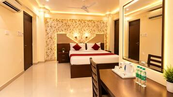 A hotel room with a bed, bedside table, mirror, and a desk with a chair.