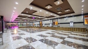 A spacious hotel lobby with a checkered marble floor, recessed lighting, and a reception desk. - Royal Mansion Lawns (Kanpur)