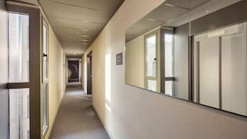 Pasillo de hotel con puertas numeradas 326, 327 y 328.