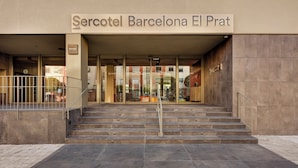 De ingang van het Mercotel Barcelona El Prat hotel, met een trap die naar de ingang leidt.