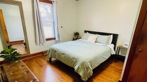 A bedroom with a bed, wooden floor, ceiling fan, and a nightstand with a lamp. - Quiet 3-bedroom house in Mexico, Kentucky (Marion)