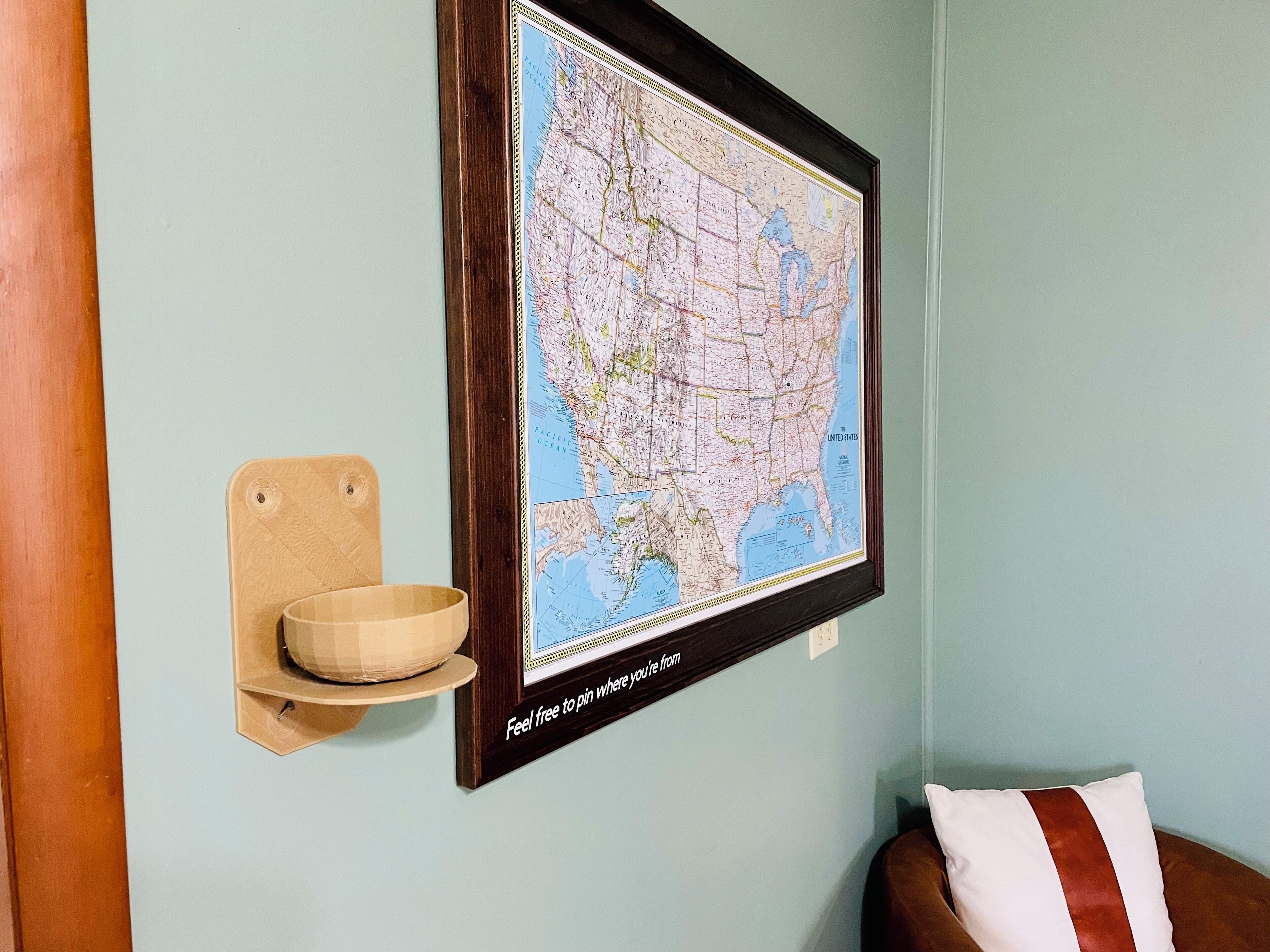 Un mapa enmarcado en una pared, con un estante de madera debajo.