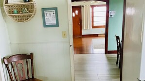 A hallway leading to a room with a wooden chair, a refrigerator, and a ceiling fan. - Quiet 3-bedroom house in Mexico, Kentucky (Marion)