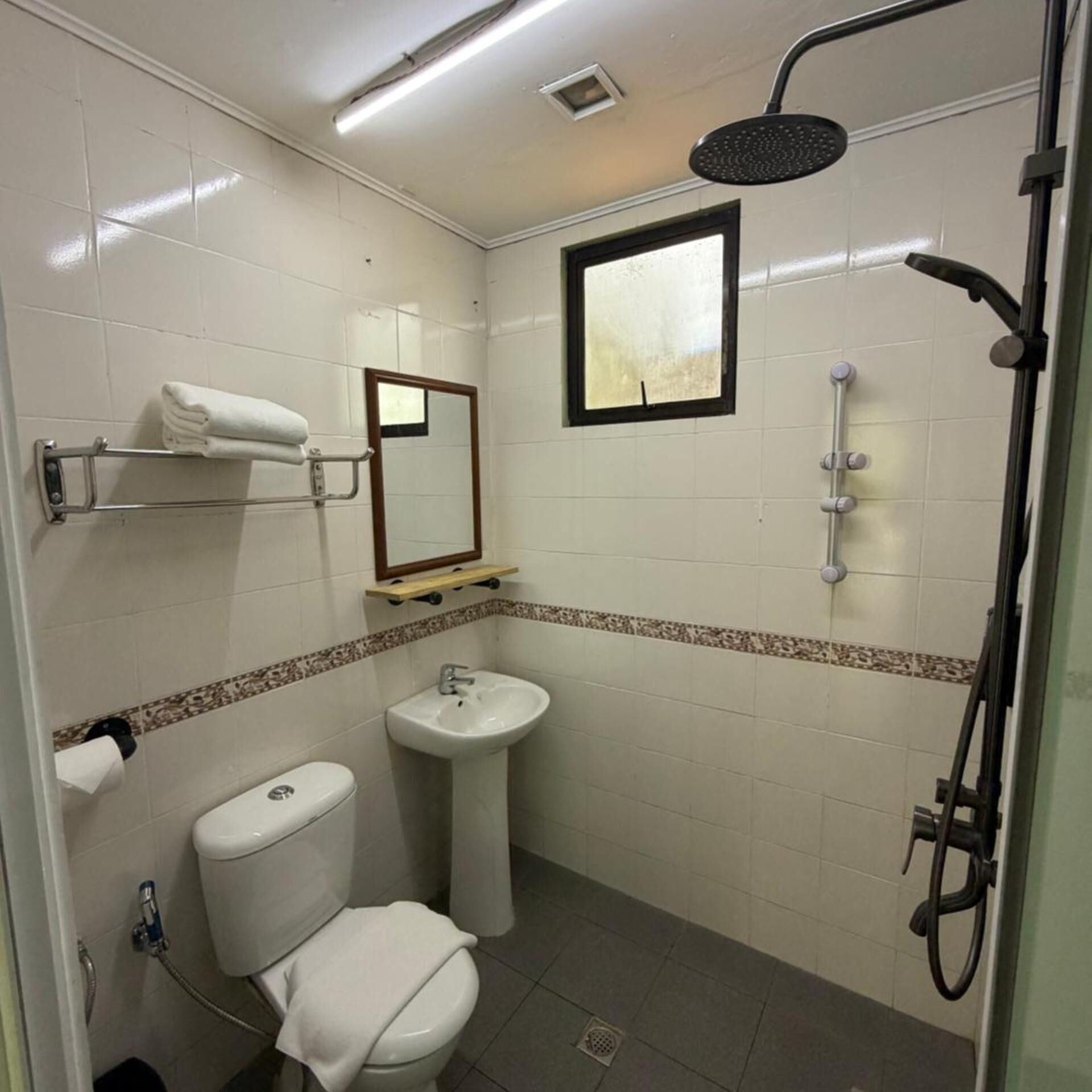 A compact bathroom with a toilet, sink, and shower.
