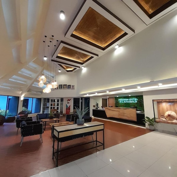 A hotel lobby with a reception desk, seating area, and a large window. - Perkasa Hotel Mt Kinabalu (Ranau)