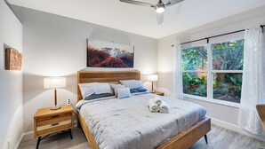 A bedroom with a bed, nightstands, a ceiling fan, a window with curtains, and a painting on the wall. - NAPLES 2B/2B IMPERIAL CONDO W/ STYLE & LAKE VIEWS! POOLS! NEAR EVERYTHING! 102 (Naples)