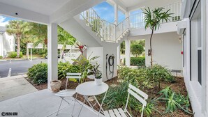 A covered outdoor area with a white staircase, seating, and potted plants. - NAPLES 2B/2B IMPERIAL CONDO W/ STYLE & LAKE VIEWS! POOLS! NEAR EVERYTHING! 102 (Naples)