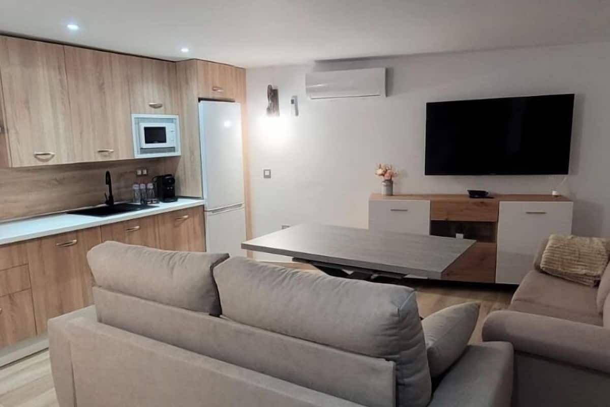 Ein modernes Wohnzimmer mit einer Couch und einem Fernseher.