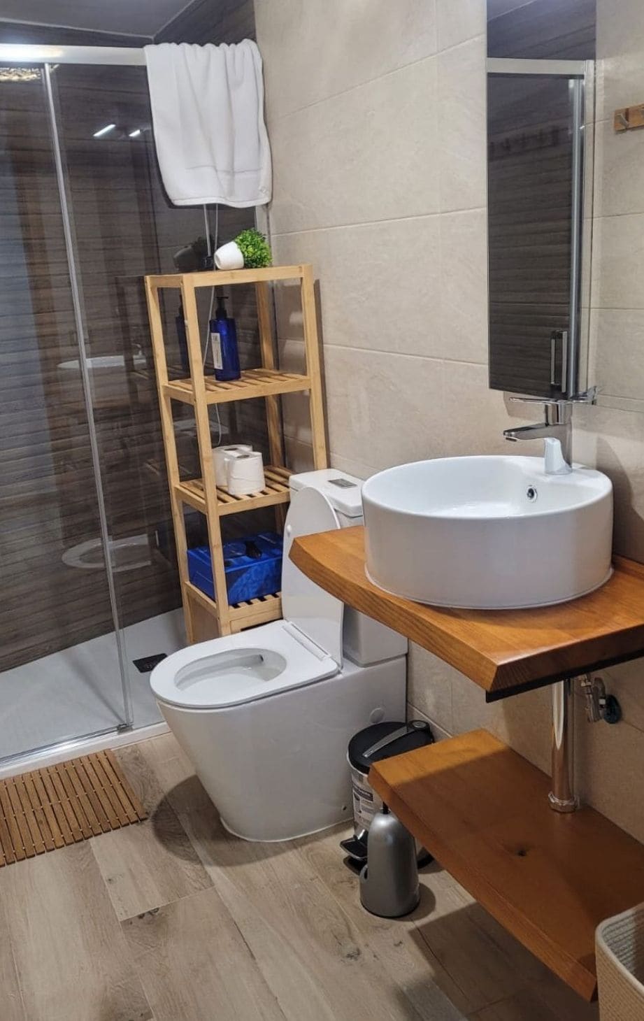Un bany modern amb vàter, un lavabo i una zona de dutxa.