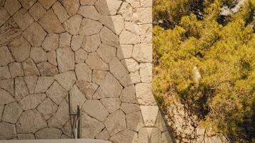 Une salle de bain avec un mur en pierre, une baignoire et un sol carrelé.