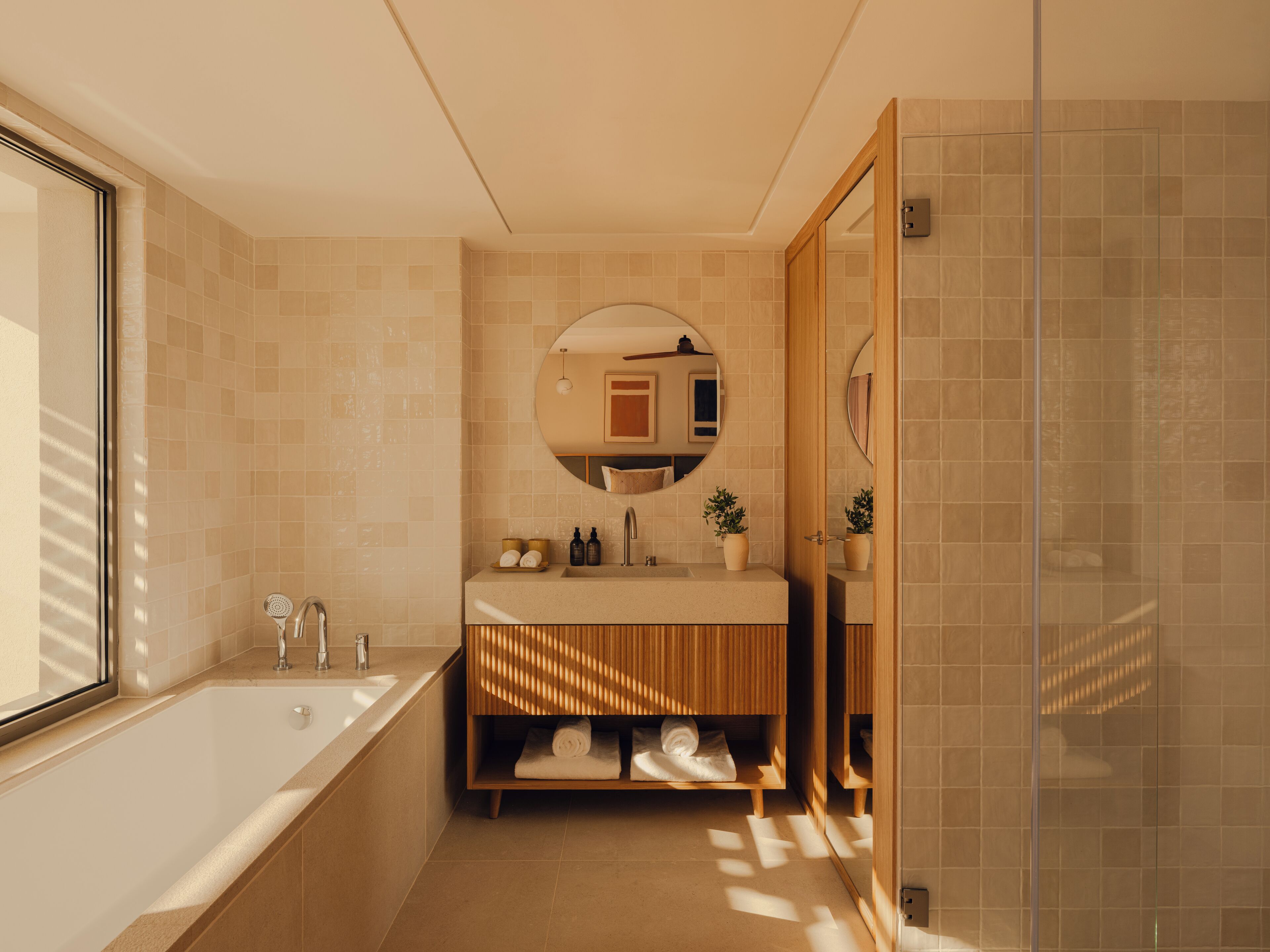 A modern bathroom with a bathtub, sink, and shower.