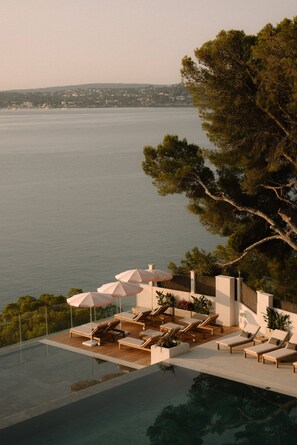 Piscine couverte, piscine extérieure, parasols de plage, chaises longues