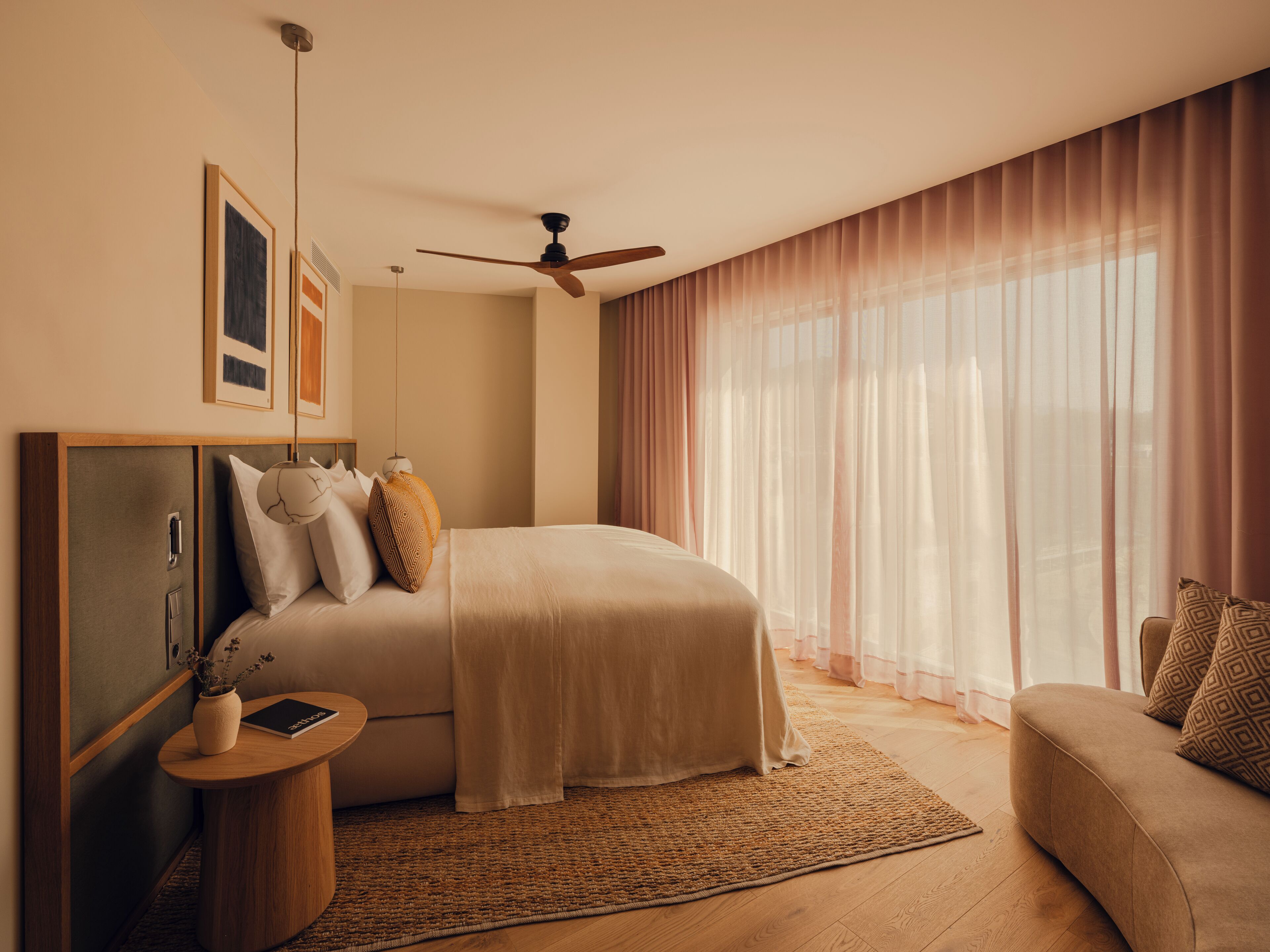 Un dormitorio con cama, mesita de noche y ventilador de techo.