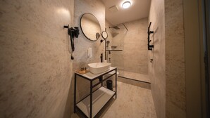 Een moderne badkamer met een grote spiegel, een wastafel en een douche.