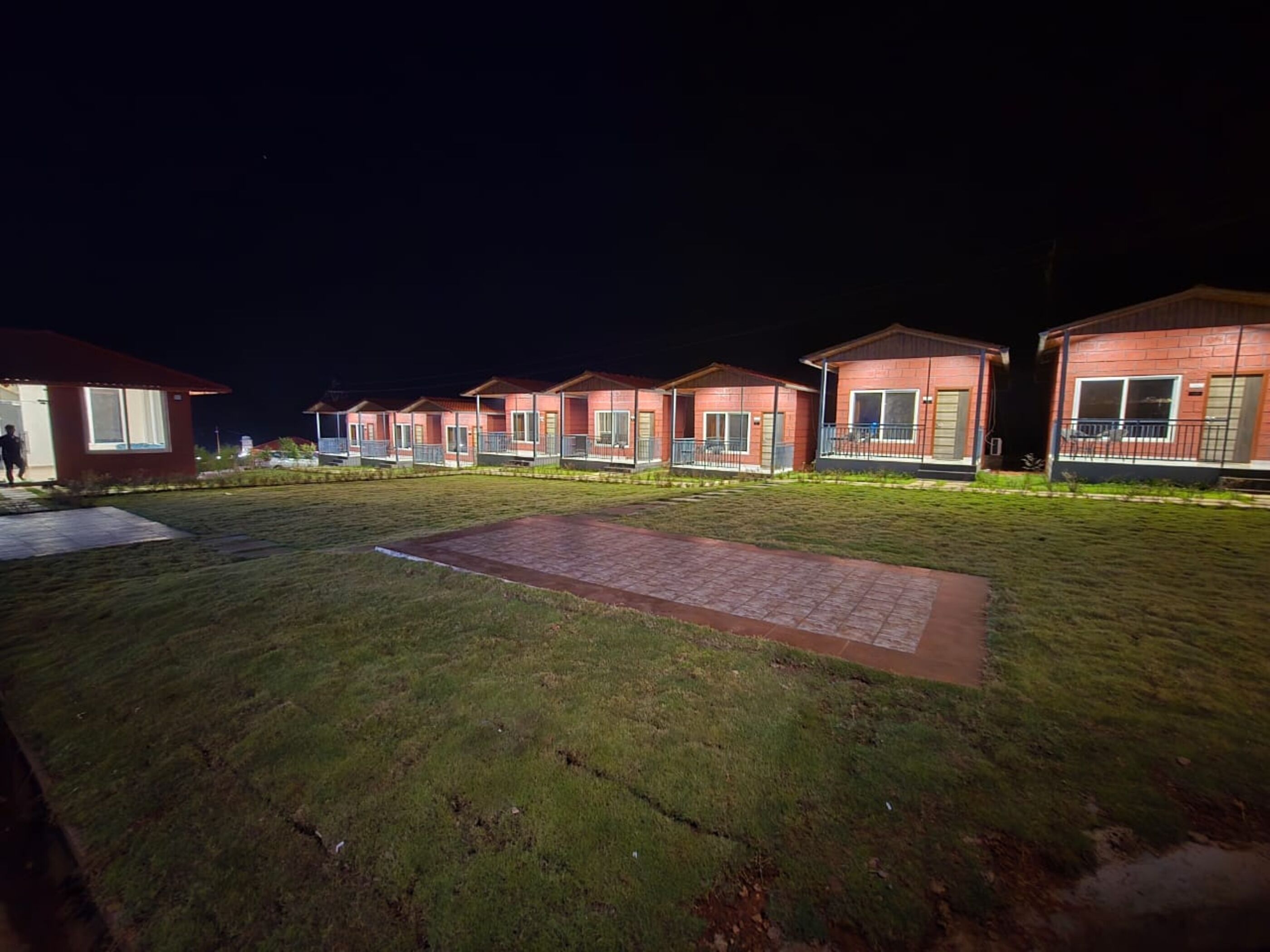 Een rij huisjes met één verdieping, met een geplaveid voetpad op de voorgrond.