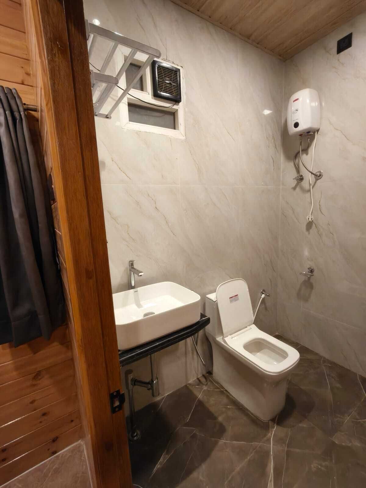 Een badkamer met toilet, wastafel en douche.