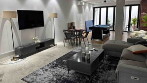 A modern living room with a flat-screen TV, a pool table, a sofa, and a dining area. - Nara s Luxe Villa#pooltable#karaoke#partyhouse (Pelabuhan Klang)